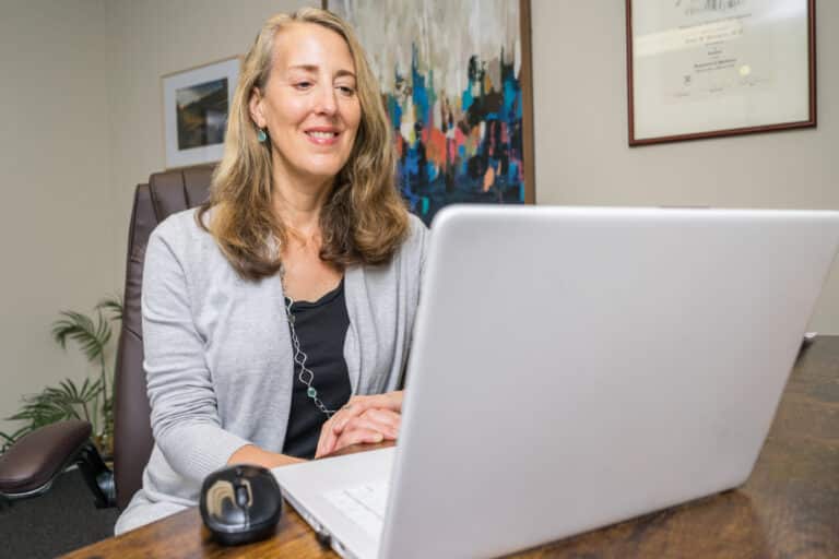Dr. Emily Bernstein sits at her laptop.