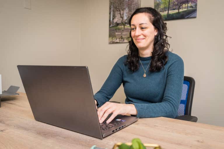 Elizabeth Milburn, CRNP, sits at her laptop.