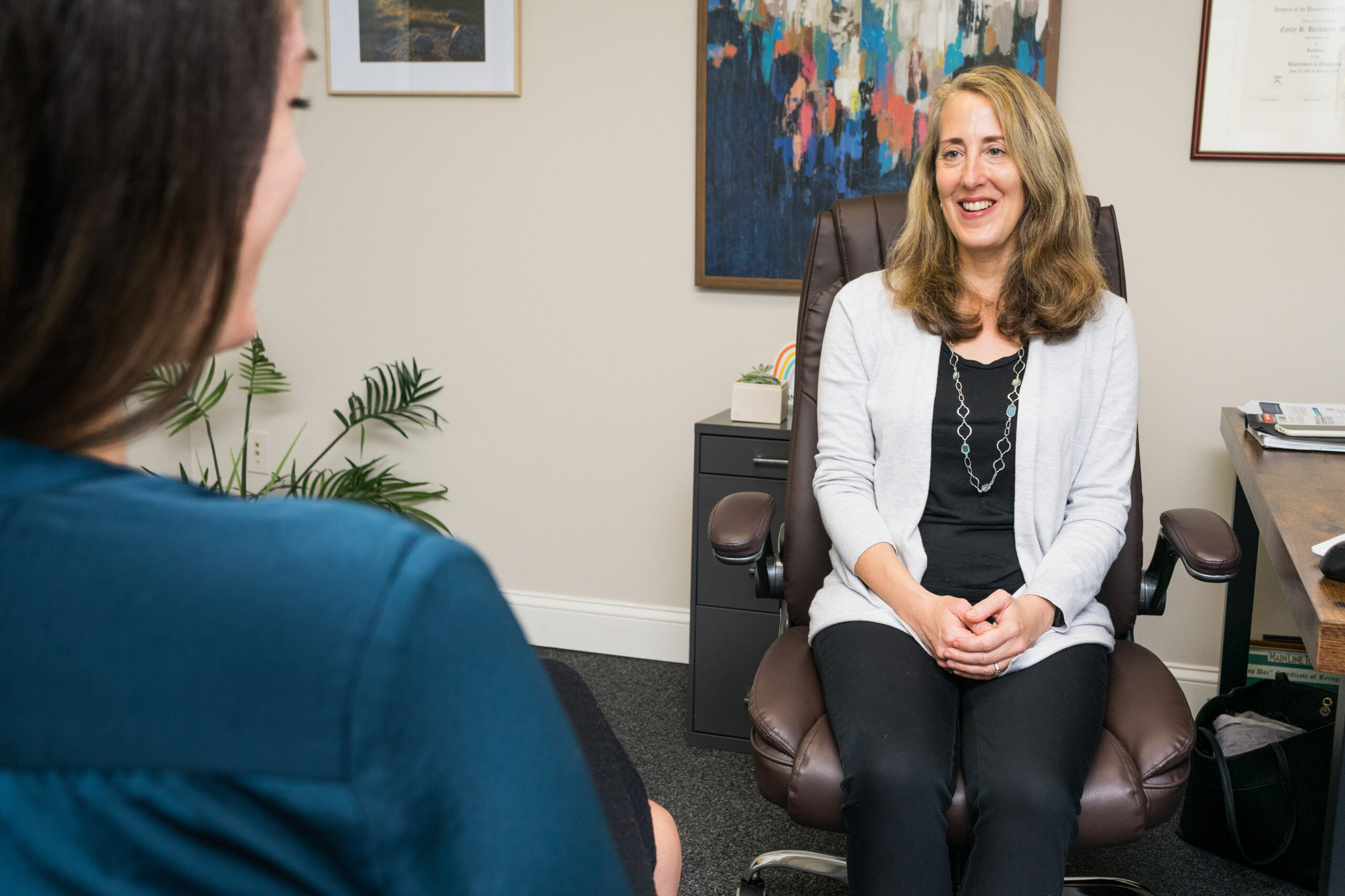 Dr. Emily Bernstein sits at a meeting desk.